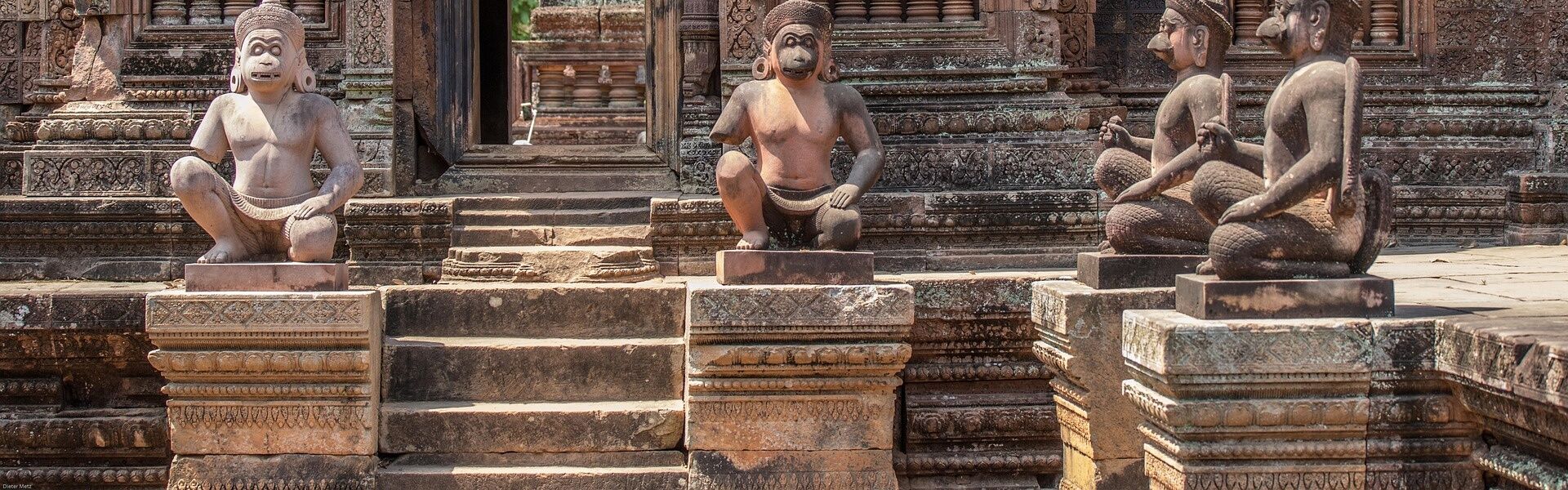Visitors at Bayon Temple’s stone faces on an Angkor Thom Tours adventure with Legend Travel Group in Cambodia.