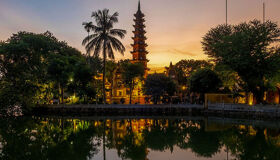 Serene Hanoi temple at sunset on a Hanoi Tours banner by Legend Travel Group.