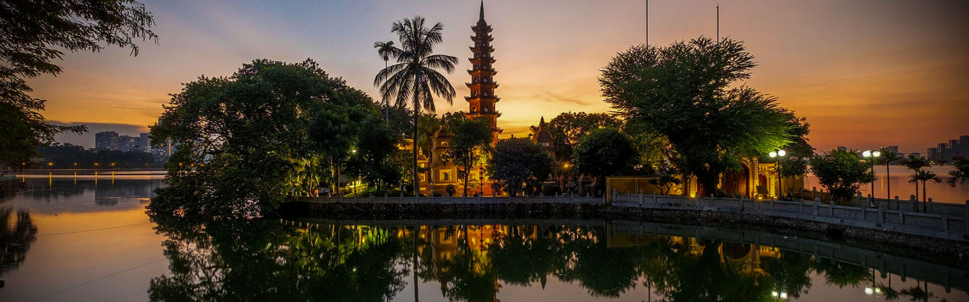 Serene Hanoi temple at sunset on a Hanoi Tours banner by Legend Travel Group.