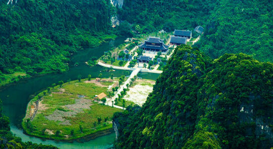Lush greenery and karst mountains during a guided Trang An Tours experience with Legend Travel Group.