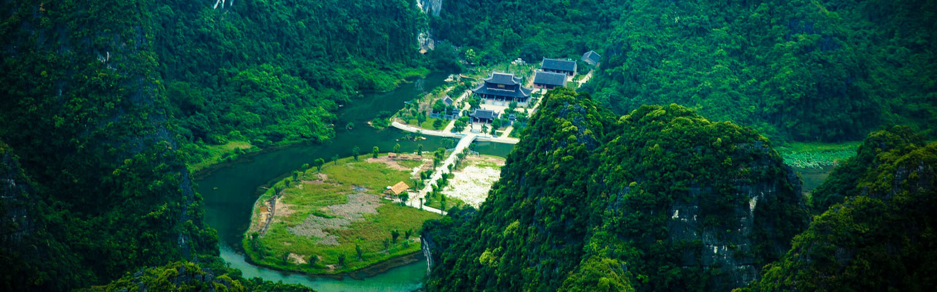 Lush greenery and karst mountains during a guided Trang An Tours experience with Legend Travel Group.