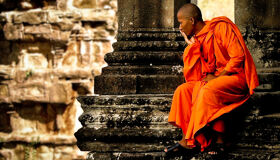 Buddhist Monk sitting at the Angkor Temples, Siem Reap